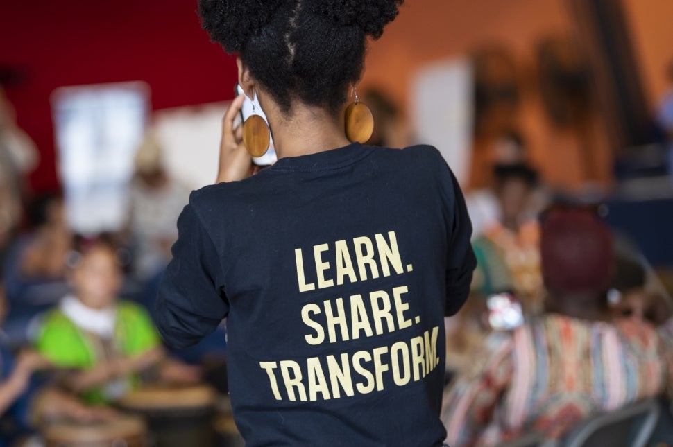 Student with t-shirt that reads "Learn. Share. Transform."