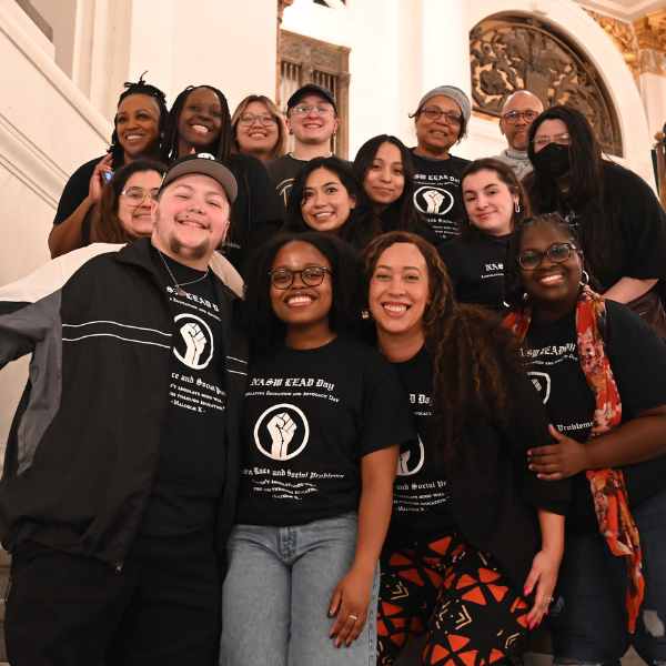 Center on Race and Social Problems Director Dr. Kyaien Conner smiling with social work students in Harrisburg