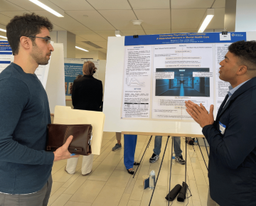 Student presenting a research poster board