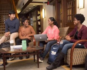 Students sit and talk in the Cathedral of Learning Honors College.